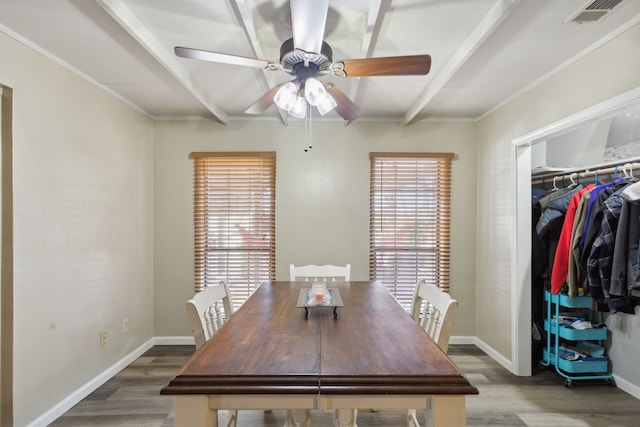 unfurnished dining area featuring a healthy amount of sunlight, visible vents, beamed ceiling, and wood finished floors