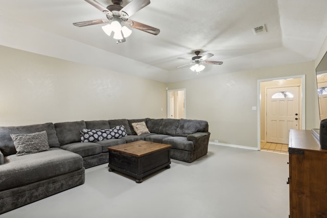 living area with baseboards, visible vents, and ceiling fan