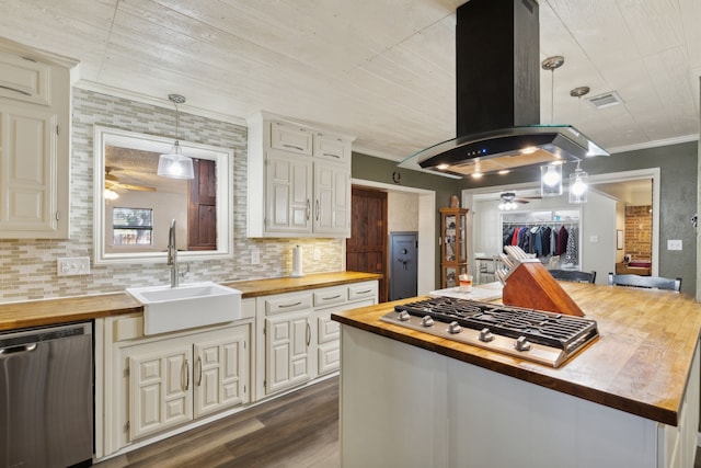 kitchen with island range hood, appliances with stainless steel finishes, ornamental molding, wooden counters, and a sink