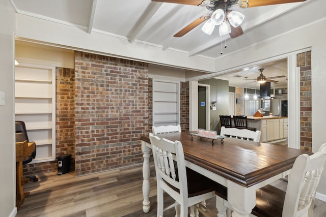 dining room with brick wall, wood finished floors, built in features, beam ceiling, and crown molding