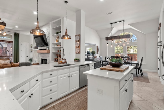 kitchen featuring lofted ceiling, white cabinetry, stainless steel dishwasher, and sink