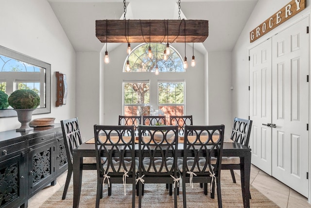 dining space featuring light tile patterned floors, a chandelier, and vaulted ceiling