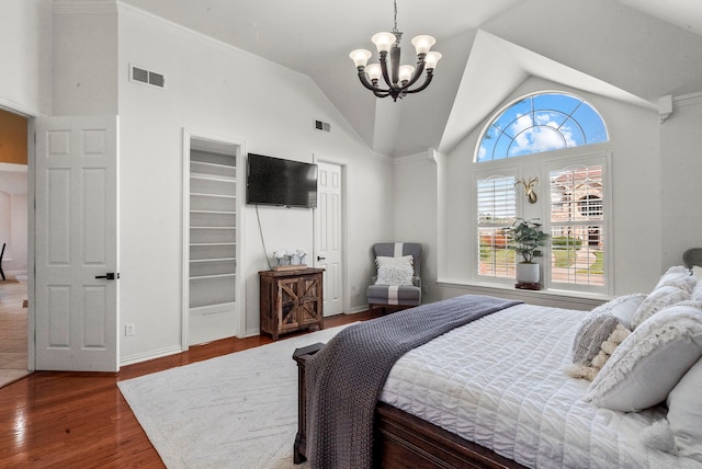 bedroom featuring ornamental molding, high vaulted ceiling, a chandelier, and wood-type flooring