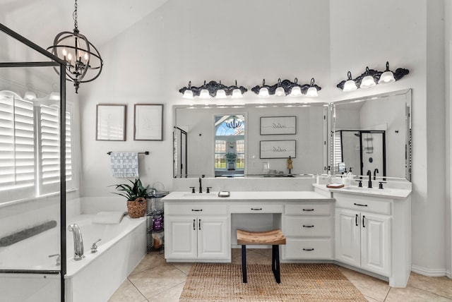 bathroom with a notable chandelier, tile patterned floors, separate shower and tub, and vanity