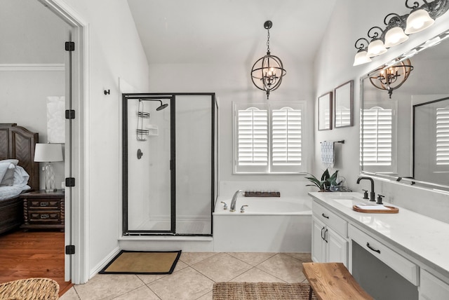 bathroom featuring lofted ceiling, a notable chandelier, vanity, and independent shower and bath