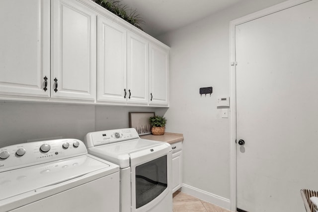 laundry room featuring cabinets, washing machine and dryer, and light tile patterned flooring