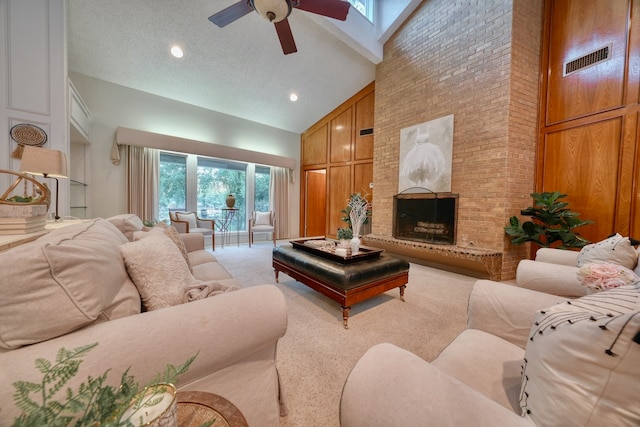 living room featuring carpet flooring, a textured ceiling, ceiling fan, high vaulted ceiling, and a fireplace