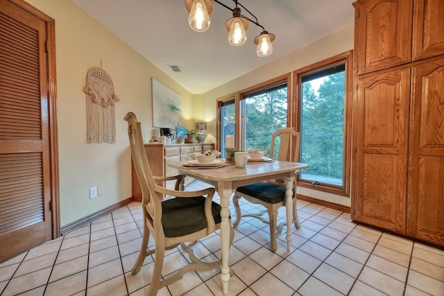 dining area with light tile patterned floors and vaulted ceiling