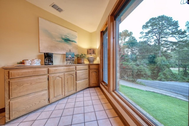 interior space featuring vaulted ceiling, tile patterned floors, and a healthy amount of sunlight