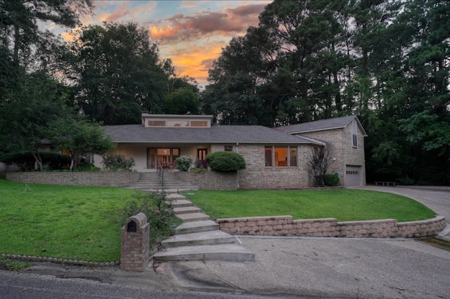 view of front of house featuring a yard, a porch, and a garage