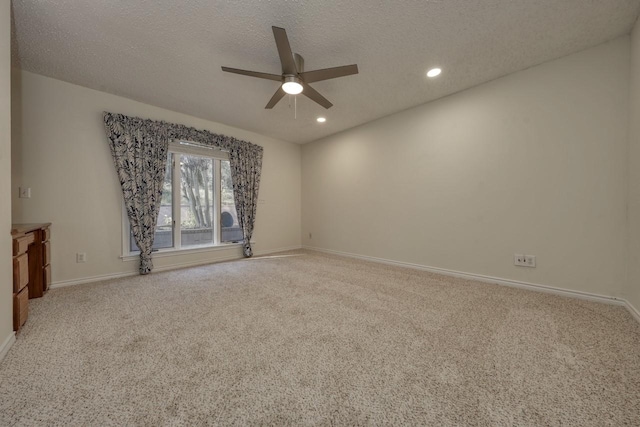 carpeted empty room featuring ceiling fan and a textured ceiling