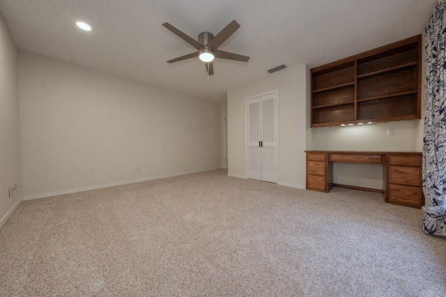 unfurnished bedroom featuring a textured ceiling, a closet, ceiling fan, and light colored carpet