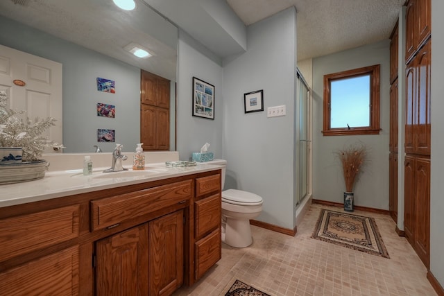 bathroom with tile patterned floors, a textured ceiling, toilet, vanity, and a shower with shower door