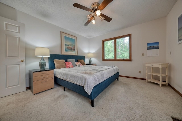 carpeted bedroom featuring ceiling fan and a textured ceiling