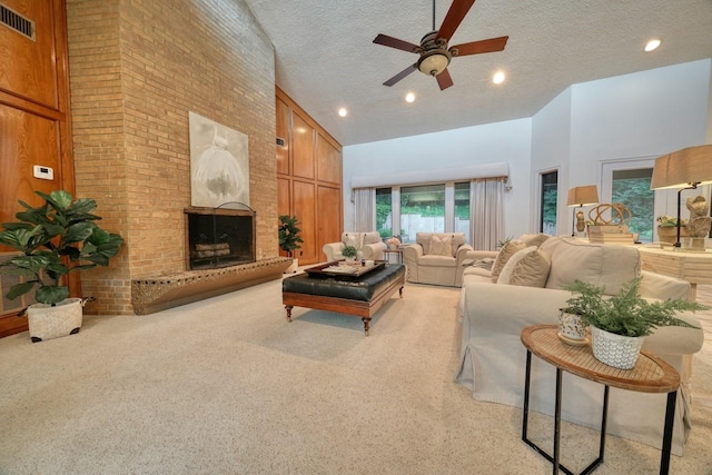 carpeted living room featuring ceiling fan, a textured ceiling, high vaulted ceiling, and a brick fireplace