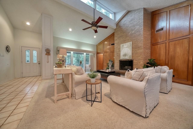 tiled living room with ceiling fan, a fireplace, a textured ceiling, and high vaulted ceiling