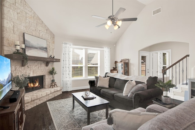 living room featuring dark wood-type flooring, high vaulted ceiling, a fireplace, and ceiling fan