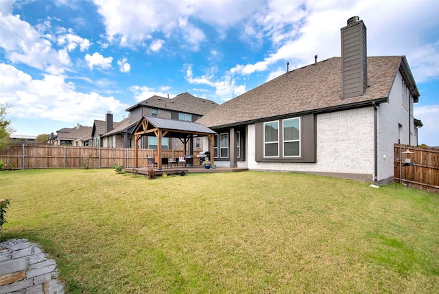 back of property featuring a gazebo and a yard