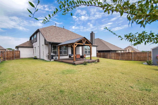 rear view of property with a yard and a wooden deck