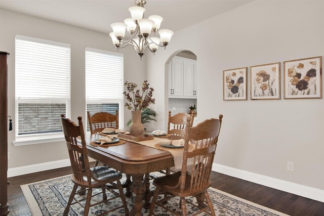 dining space with an inviting chandelier and dark wood-type flooring