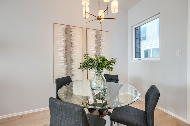 dining room with light hardwood / wood-style flooring and an inviting chandelier