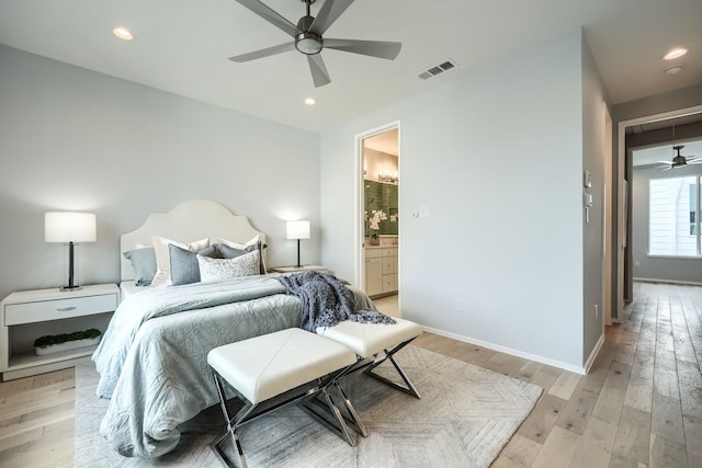 bedroom featuring ensuite bath, ceiling fan, and light wood-type flooring