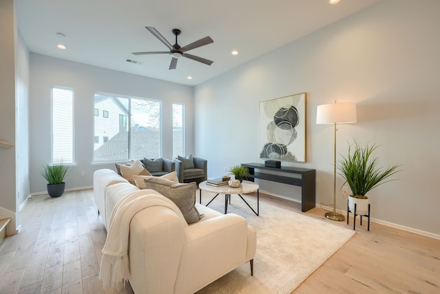 living room featuring light hardwood / wood-style flooring and ceiling fan