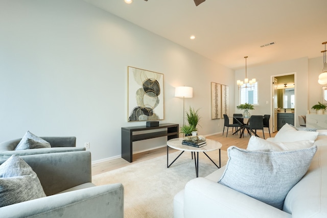 living room with a notable chandelier and light hardwood / wood-style floors