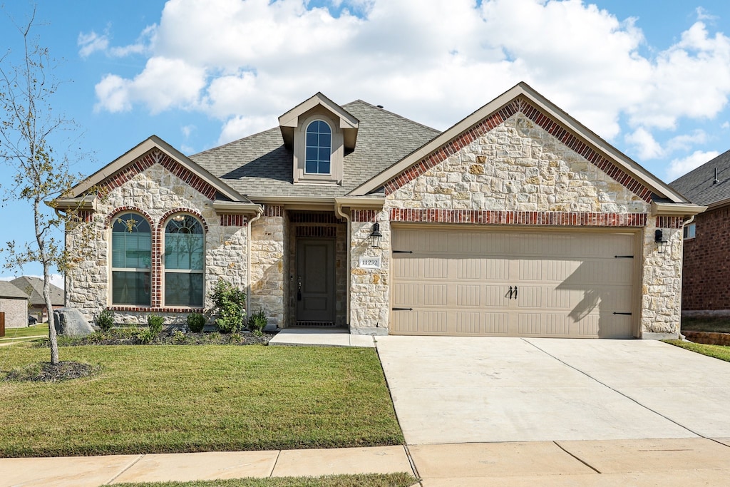 view of front of property featuring a front yard and a garage