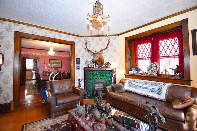 living room with ornamental molding, a fireplace, hardwood / wood-style floors, and a chandelier