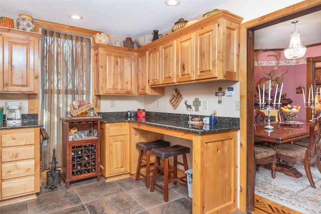 kitchen with dark stone countertops, hanging light fixtures, and a chandelier