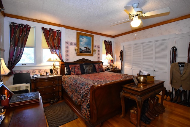 bedroom with ceiling fan, a closet, hardwood / wood-style floors, crown molding, and a textured ceiling