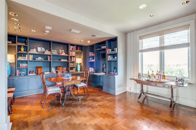 dining area featuring light parquet floors and built in desk