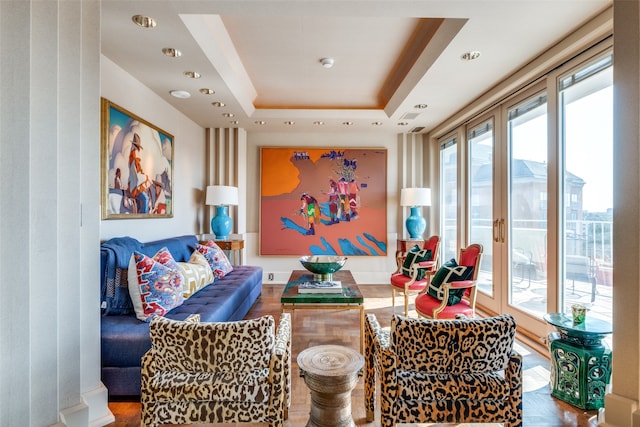 game room with a tray ceiling and hardwood / wood-style floors