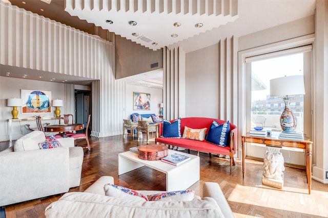 living room with a towering ceiling and parquet flooring