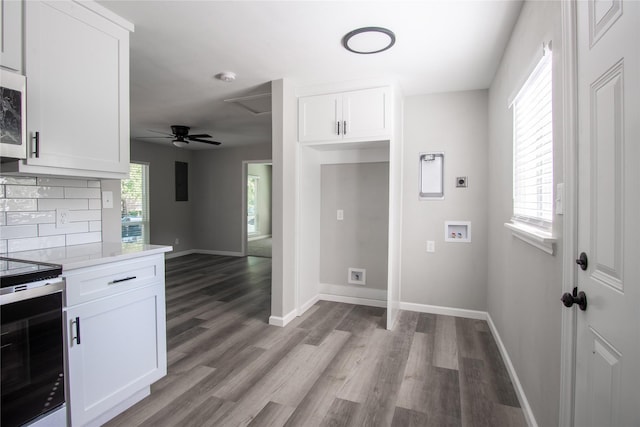 washroom featuring washer hookup, electric dryer hookup, dark wood-type flooring, and cabinets