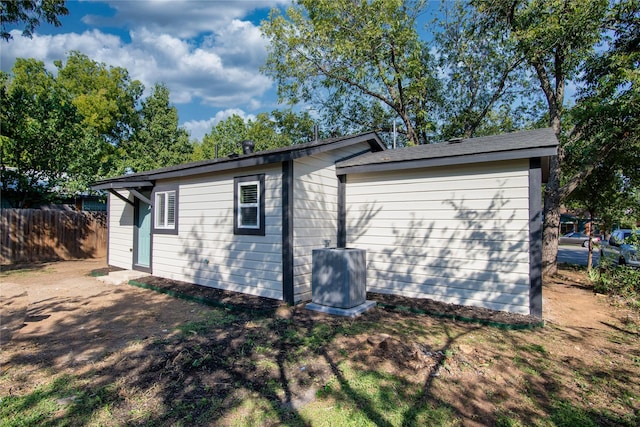 view of front of property with a front lawn and central air condition unit