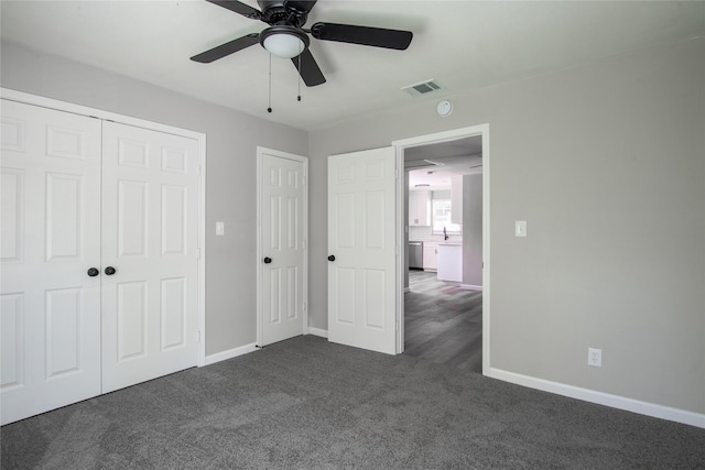 unfurnished bedroom with a closet, ceiling fan, and dark carpet