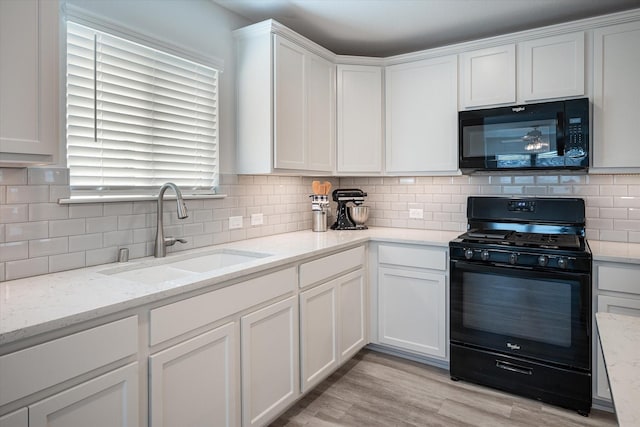 kitchen with decorative backsplash, white cabinetry, and black appliances