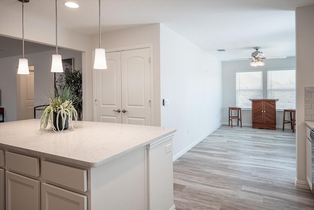 kitchen featuring a kitchen breakfast bar, stainless steel fridge, decorative light fixtures, decorative backsplash, and white cabinets