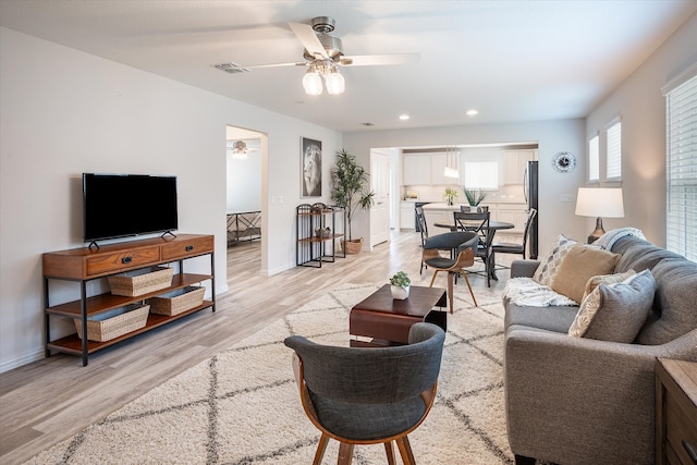 living room featuring ceiling fan and light hardwood / wood-style floors