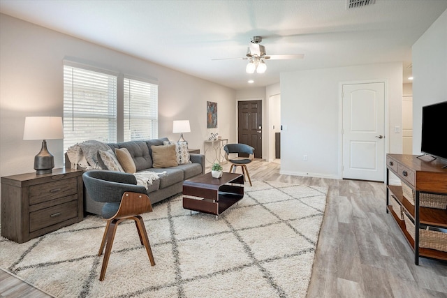 living room featuring light hardwood / wood-style flooring and ceiling fan