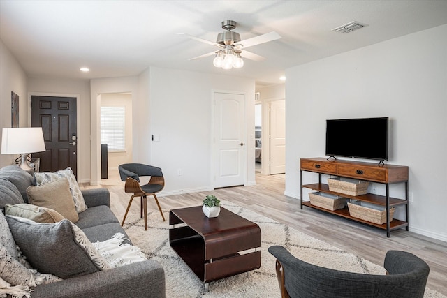 living room with ceiling fan and light hardwood / wood-style floors