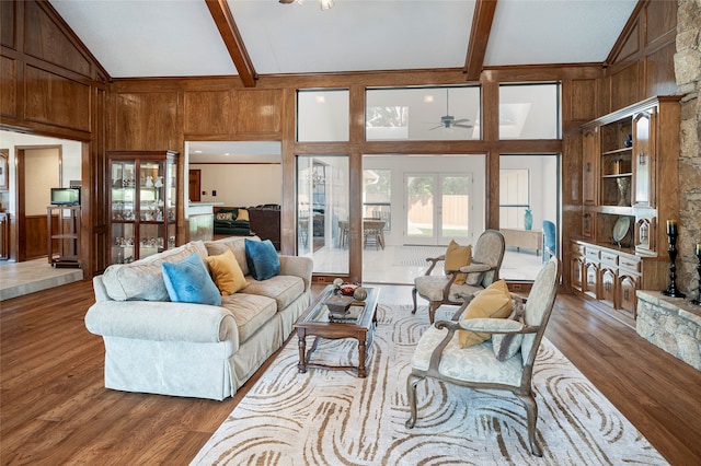 living room featuring wood-type flooring, beamed ceiling, high vaulted ceiling, and ceiling fan