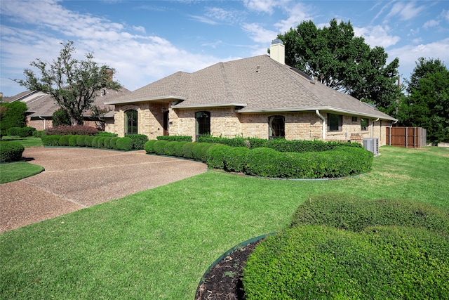 view of front of property featuring central AC unit and a front lawn