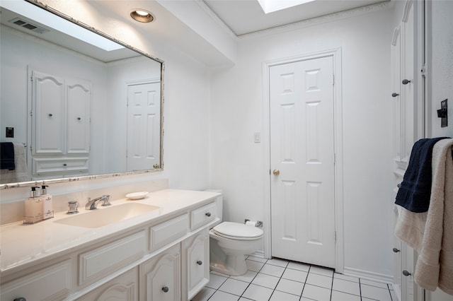 bathroom with vanity, ornamental molding, tile patterned floors, a skylight, and toilet