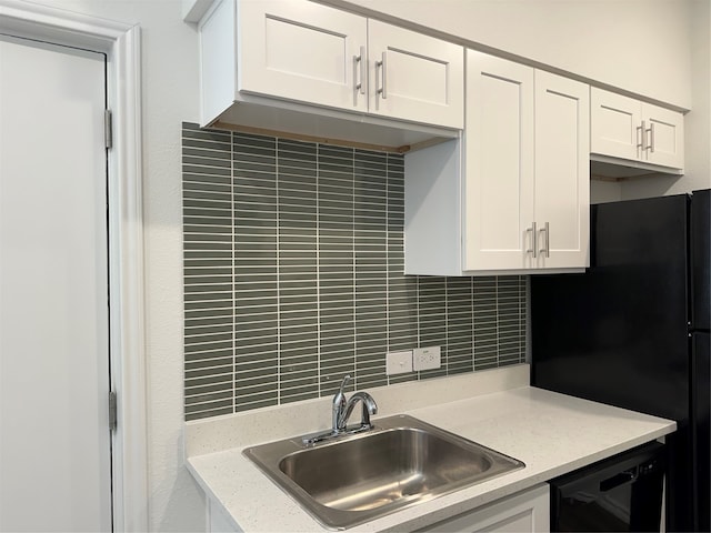 kitchen with black appliances, sink, backsplash, white cabinets, and light stone counters