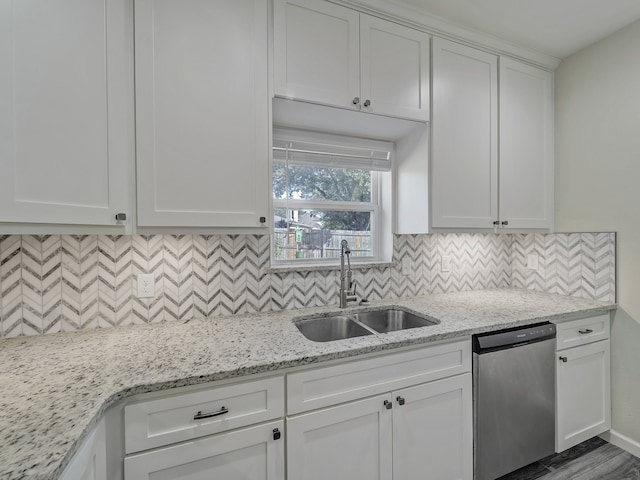 kitchen with sink, light stone counters, white cabinetry, and dishwasher