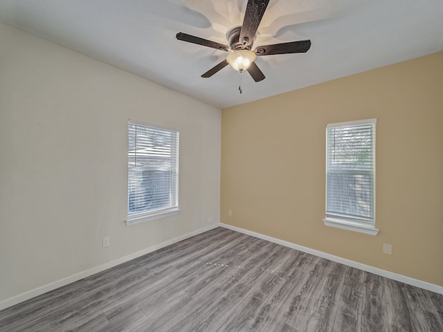 empty room featuring hardwood / wood-style floors, a healthy amount of sunlight, and ceiling fan