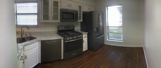 kitchen with white cabinets, appliances with stainless steel finishes, sink, and dark hardwood / wood-style flooring